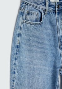 Jeans de denim de cintura alta en azul claro, con un diseño clásico de cinco bolsillos, costuras visibles y una ligera textura deslavada.