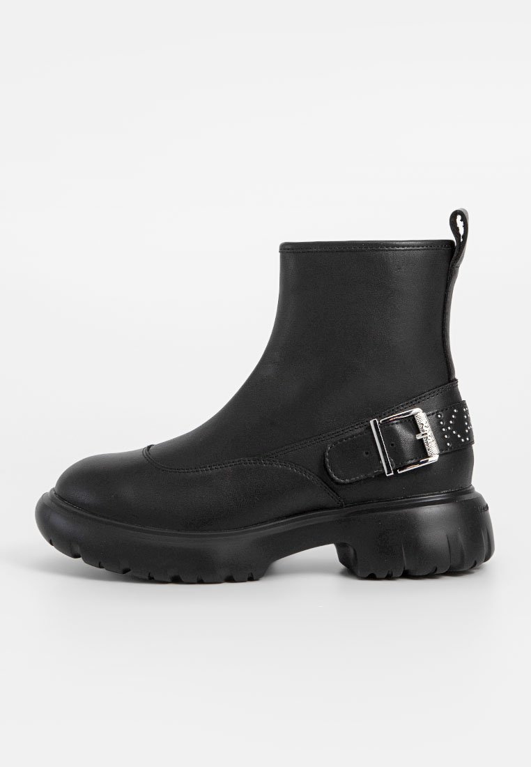 Schwarze Knöchelstiefel aus glattem synthetischen Material mit einer klobigen Sohle, seitlichem Riegel und Nietenakzent.