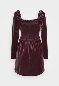 Burgundy sammetklänning med fyrkantig urringning, puffärmar, smockad bodice och en flerad kjoldesign. Slät textur, knä-längd.