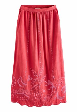 Jupe rouge avec des motifs brodés comprenant un singe, des bananes, un papillon, un croissant de lune, un œil et des feuilles le long de l'ourlet inférieur.