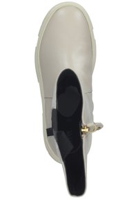 Botte de cheville en cuir beige avec un bout arrondi, un panneau latéral élastique et un détail en métal doré, dotée d'une semelle texturée blanche.