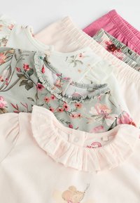 Vijf stukken kinderkleding: bloemmotieven op grijze en witte tops met ruches; roze shorts; zacht katoenmateriaal.
