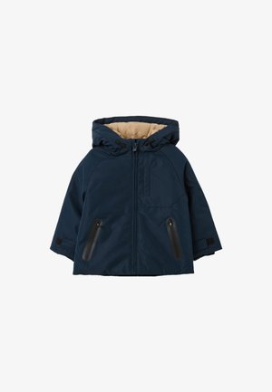 Donkerblauwe hoodie-jack met een tan kleurige binnenvoering, vooraan met een rits en twee ritszakken aan de zijkanten; voorzien van zwarte hardware en een verstelbare capuchon.