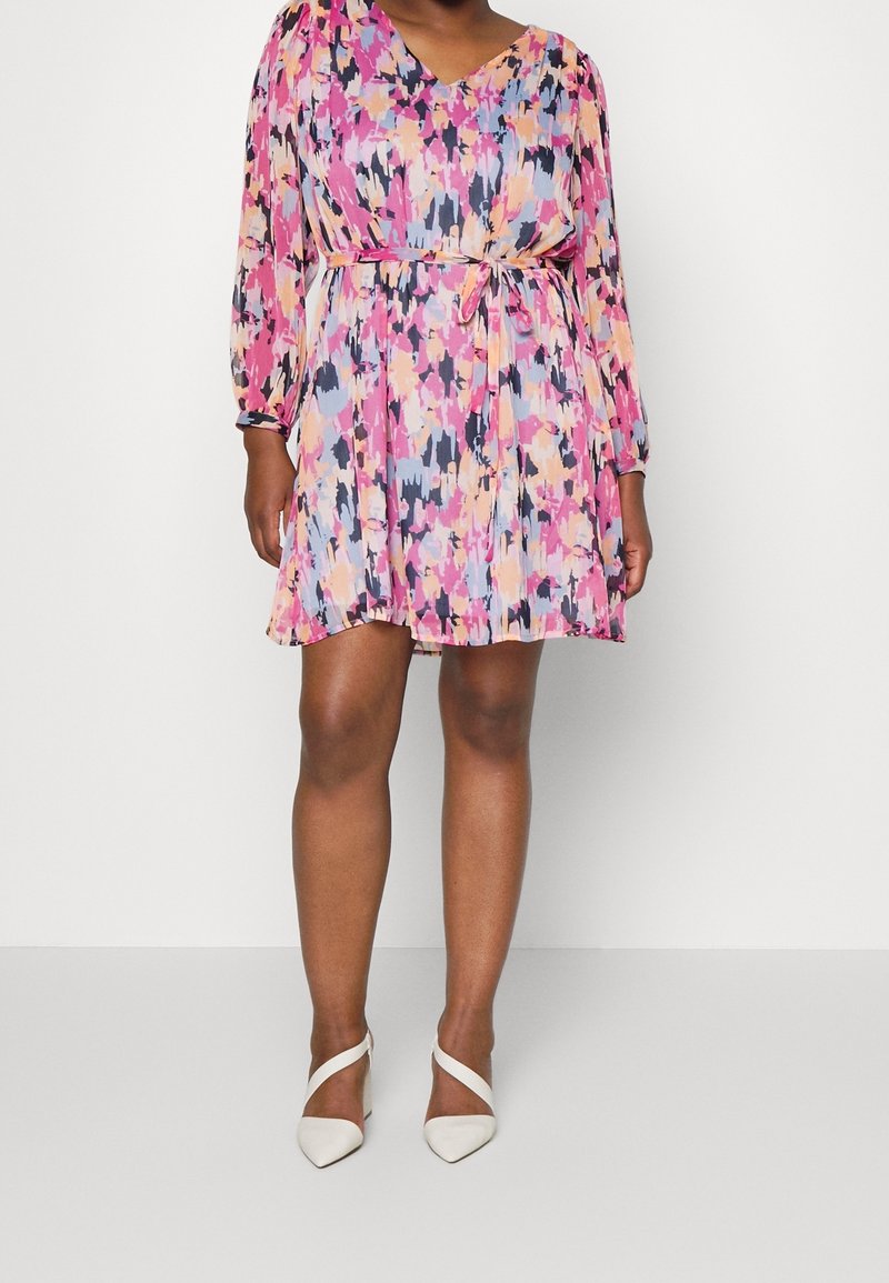 Krátký rukáv, šaty s výstřihem do V v barevném abstraktním vzoru s růžovými, modrými a černými odstíny; stažený pas s uvázaným páskem.