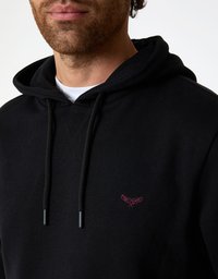 Schwarzer Kapuzenpullover aus Baumwolle mit strukturierter Kapuze, Kordelzügen und einem kleinen burgunderroten gestickten Logo auf der Brust.