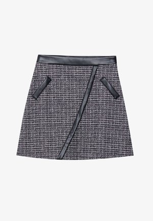 Jupe mini en tweed tissé noir et gris avec une taille en cuir lisse et des poches accentuées, présentant un design de panneau avant anglé.
