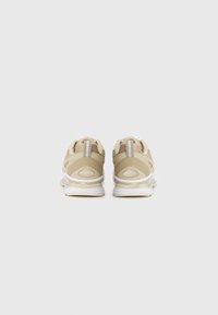 Beige athletic shoes with mesh and leather materials, round toe, white midsole, and reflective accents. Rear view shows branded detailing.