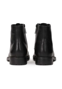 Botine negre din piele, cu un finisaj neted, având vârf rotund, fermoare pe lateral și o talpă groasă din cauciuc pentru aderență.