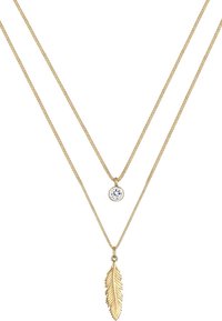 Goldfarbene, mehrschichtige Halskette mit einem Kristallanhänger und einem blattförmigen Charm, die beide an zarten, ineinander verschlungenen Ketten hängen.