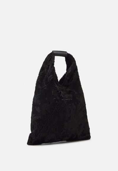 Saco preto com um padrão floral texturizado. Apresenta uma forma triangular única e uma alça robusta e elegante. Material suave e macio.