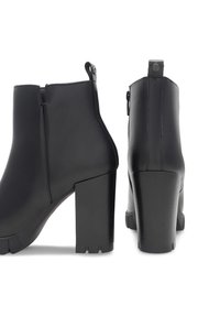Czarne botki za kostkę wykonane z gładkiej skóry, z wysokim obcasem w kształcie bloku, z bocznym zamkiem błyskawicznym i wyraźnym uchwytem z tyłu.