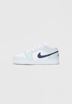 Heledad sinised ja valged Nike tossud, millel on sujuv nahk peal, kontrastne tumesinine swoosh ja tekstureeritud kummist tallad. Sidumisnöörid ja polsterdus on valged.