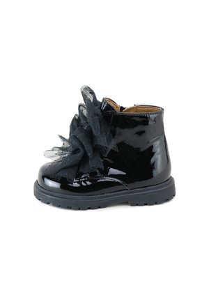 Botín de tobillo de charol negro con adornos de tul negro texturizado y suela de goma. Cuenta con costuras discretas y diseño de punta redonda.