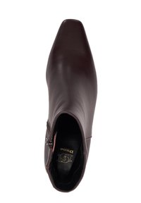 Brown leather ankle boot with a pointed toe and side zipper. Smooth texture, minimalistic design, and a branded insole featured inside.