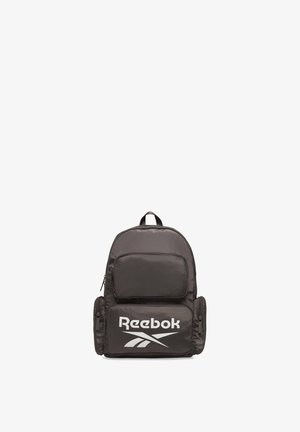 Czarny plecak Reebok z wieloma zamykanymi na zamek kieszeniami i dużym białym logo Reebok na przedniej kieszeni.