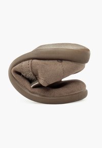 Brauner faltbarer Hausschuh mit weichem Obermaterial aus Stoff und Gummisohle, der ein flexibles Design für eine einfache Aufbewahrung bietet. Flache und runde Form.