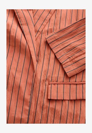 Koral värvi puuvillane jakker, millel on vertikaalsed hallid triibud, narmastega krae, üks rinnakott ja tekstureeritud kangas.