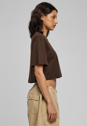 Bruine cropped t-shirt met korte mouwen, met een eenvoudig ontwerp en een zachte textuur, gecombineerd met beige cargobroeken met zijzakken.