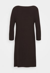 Stickad klänning i mörkbrun med en avslappnad, bred halsringning. Har trekvartsärmar och sidofickor för ökad rörlighet.