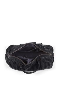 Musta kudottu nahkainen matkakassi, jossa on kaksinkertaiset yläkahvat, vetoketjusulku ja tilava sisustus, jossa on useita lokeroita.