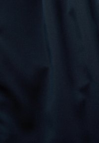 Tissu bleu marine foncé avec des plis subtils et une texture douce et lisse.