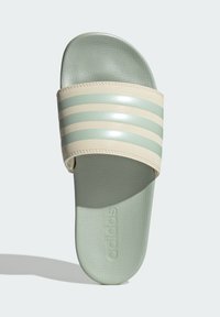 Adidas slippers met een zachte mintgroene voetbed, glanzende beige band met lichtgroene strepen en gestructureerde zolen voor grip.