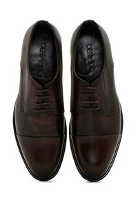 Zapatos de cuero marrón con un acabado texturizado, que cuentan con una puntera lisa de color oscuro, cordones redondos y una suela de goma negra. El nombre de la marca está grabado en el interior.