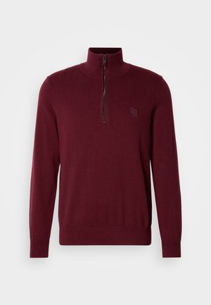 Burgundy long-sleeve knit sweater with half-zip collar and small embossed logo patch on left chest, ribbed cuffs and hem.