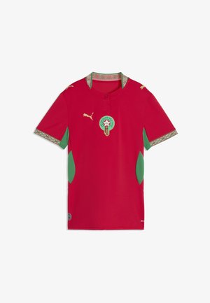 Czerwona koszulka piłkarska z krótkim rękawem, zielonymi bocznymi panelami, wzorzystym kołnierzem i mankietami, złotymi logo Puma oraz emblematem reprezentacji Maroka na piersi.