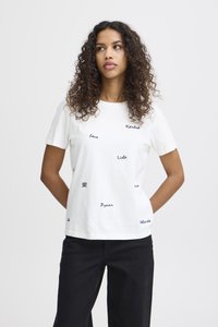 Camiseta de algodón blanca con cuello redondo, mangas cortas y frases en texto negro. Presenta un corte holgado y una ligera textura.