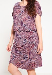 Vestido de estampado púrpura con un corte suelto y relajado, mangas cortas y cintura drapeada, adornado con intrincados diseños florales y geométricos.