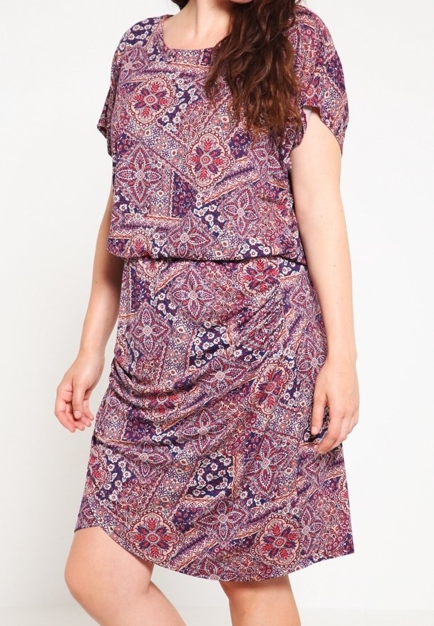 Vestido de estampado púrpura con un corte suelto y relajado, mangas cortas y cintura drapeada, adornado con intrincados diseños florales y geométricos.