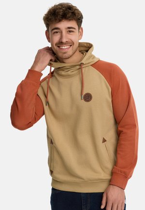 Sudadera con capucha en beige y naranja, con un parche de logo, cordones y bolsillos laterales con acentos triangulares. Tejido suave, corte relajado.