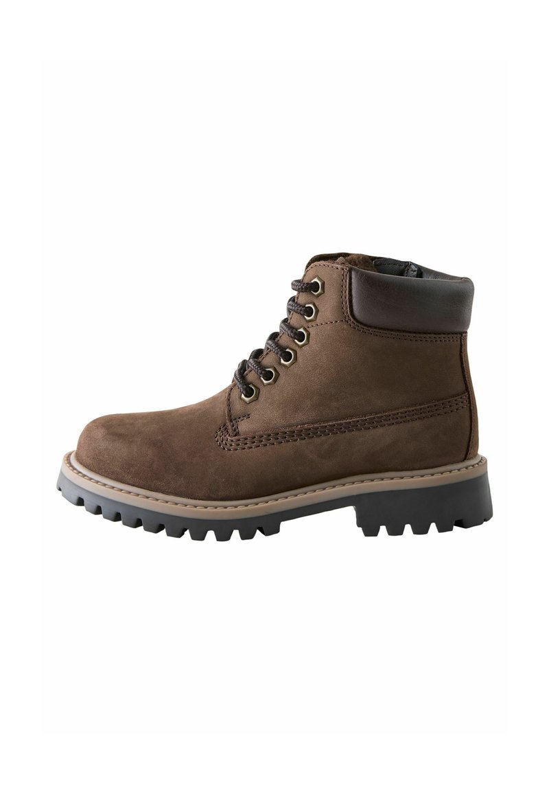 Botas de ante marrón hasta el tobillo con punta redondeada, seis ojetes, un collar acolchado y una suela de goma negra resistente con un dibujo texturizado.