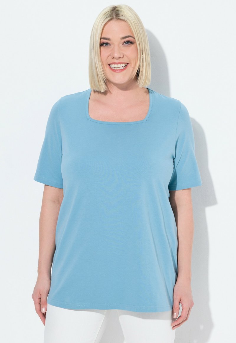 Maglietta azzurra a maniche corte con scollatura quadrata e texture liscia. Realizzata in tessuto morbido, presenta una vestibilità comoda e cuciture minime.