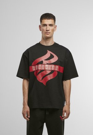 Čierne oversized tričko s veľkým červeným plameňom a bielym textom "ROCAWEAR". Vyrobené z bavlny, má krátke rukávy a okrúhly výstrih.