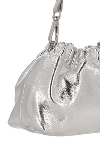 Sac à main métallique argenté avec texture froncée, doté d'une bandoulière chaîne décorative et d'une forme arrondie. Surface lisse et réfléchissante.