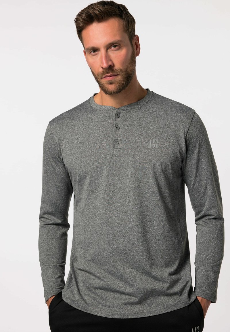 Camisa henley de manga larga gris con tres botones en el cuello, hecha de una tela texturizada, combinada con pantalones negros.