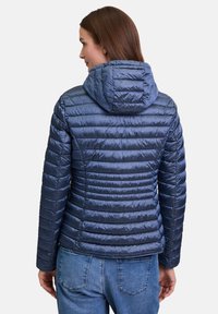 Navy blauwe gewatteerde jas met capuchon, gekenmerkt door een doorgestikt patroon en een getailleerd silhouet. Gemaakt van glanzend, lichtgewicht materiaal.