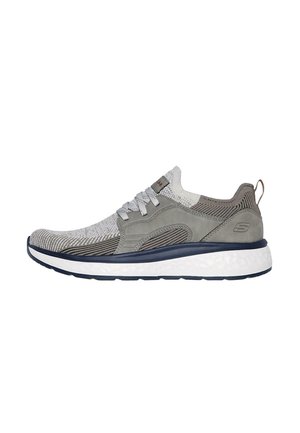 Zapatilla deportiva con un upper de punto gris y blanco, detalles en ante gris, cordones grises y una suela blanca acolchada. Cuenta con una lengüeta trasera para facilitar el calzado.