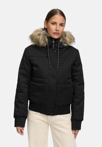 Black puffer jacket with a fur-lined hood, ribbed cuffs, snap button closure, and quilted pattern, designed for warmth and comfort.