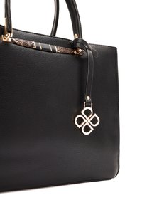 Sac fourre-tout en cuir noir avec matériel doré, accent texturé et un charm logo décoratif. Dispose de doubles poignées pour plus de polyvalence.