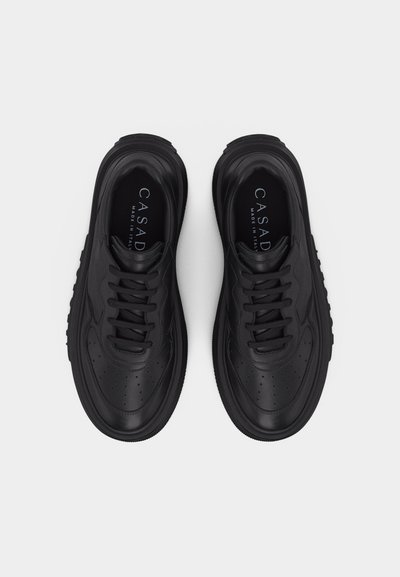 Paire de baskets noires en cuir à lacets avec semelles épaisses, marquées "CASADI Made in Italy" visibles à l'intérieur de chaque chaussure.