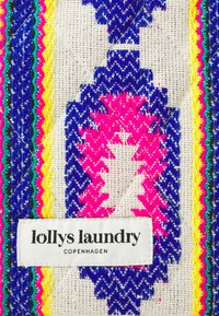 Färggam tyg med geometriska mönster i blått, rosa och gult samt en texturerad yta. Inkluderar en vit etikett med texten "lollys laundry".
