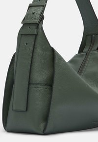 Borsa a tracolla verde in pelle con superficie testurizzata, caratterizzata da una tracolla ampia, un compartimento con zip e elementi di design angolari.