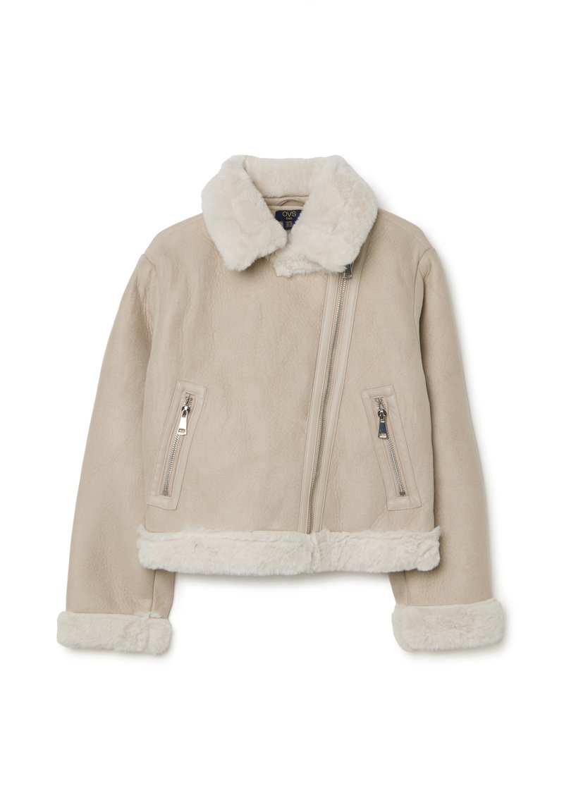 Giacca in pelle sintetica beige con colletto e polsini in pelliccia shearling. Caratterizzata da due tasche con zip e da una cerniera frontale asimmetrica.