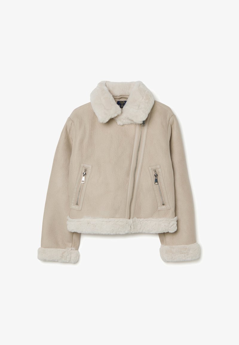 Giacca in pelle sintetica beige con colletto e polsini in pelliccia shearling. Caratterizzata da due tasche con zip e da una cerniera frontale asimmetrica.