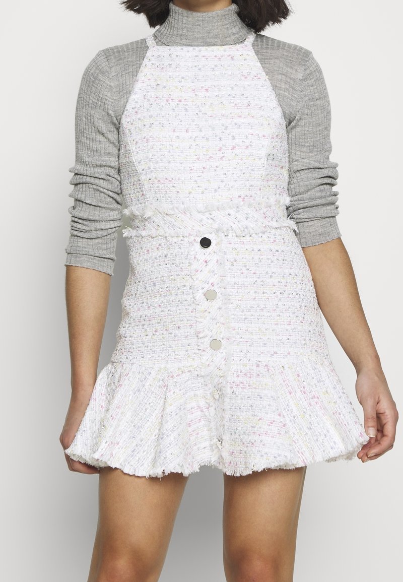 Bílá tvídová šaty se zvonovým lemem, s texturovanou vazbou a pastelovými akcenty. Přední knoflíky a úzký pas vytvářejí strukturu.