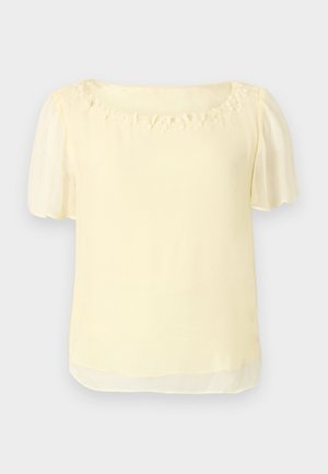 Light yellow blouse with short puff sleeves, a round neckline adorned with floral embellishments, and a smooth, lightweight texture.