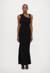 Black sleeveless dress with a fitted silhouette, asymmetrical design, and a shoulder strap featuring decorative hardware accents.